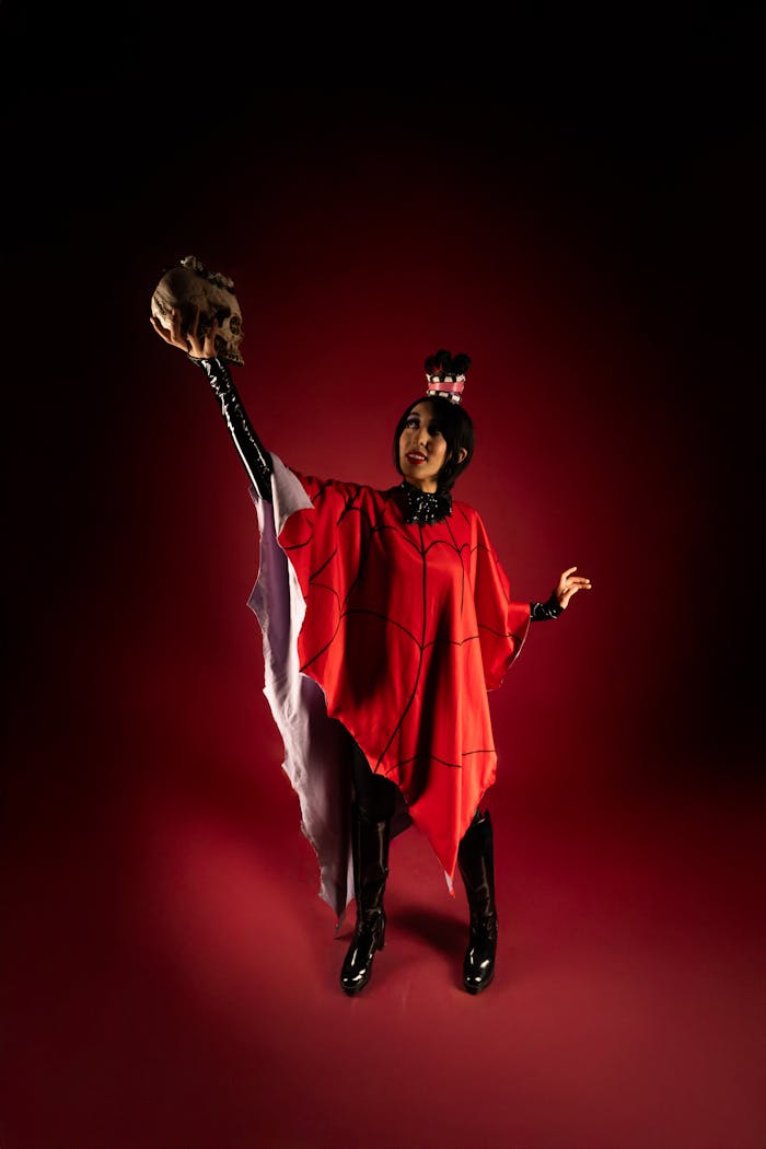 Person in cosplay holding a skull, styled with red and black in dramatic lighting.